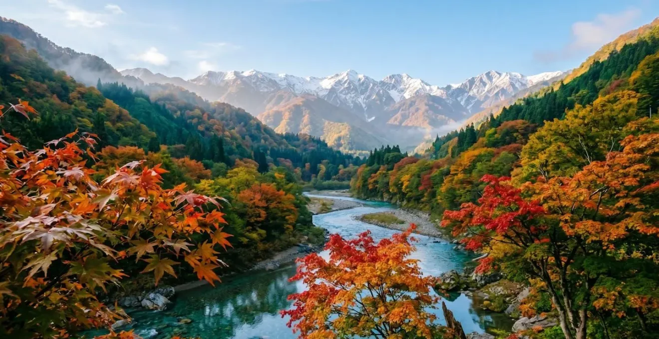 Vallée de montagne japonaise en automne avec érables rouges éclatants et sommets enneigés au loin