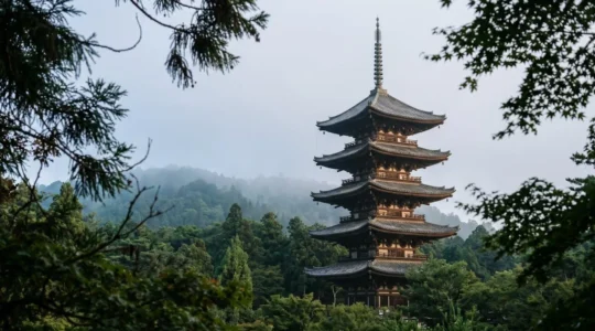 Pagode japonaise à cinq étages en bois s'élevant au-dessus de la forêt contre un ciel brumeux