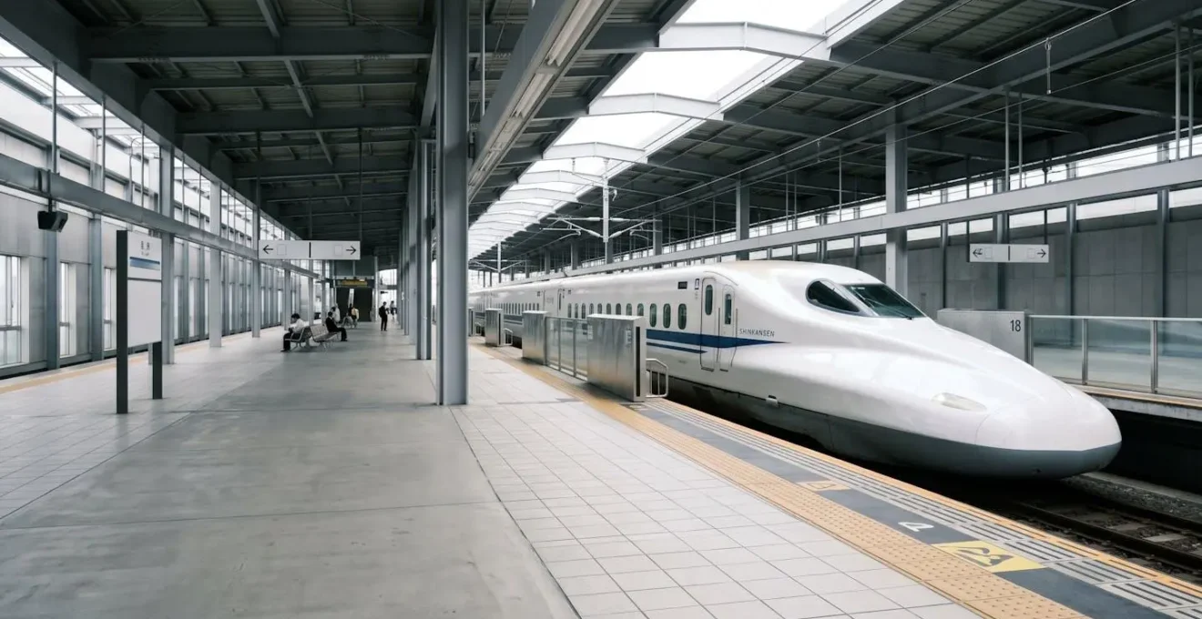 Train à grande vitesse Shinkansen dans une gare japonaise moderne avec voyageurs en attente